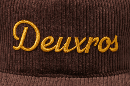 deuXros brown corduroy hat close-up embroidery detail, golden thread script on textured corduroy