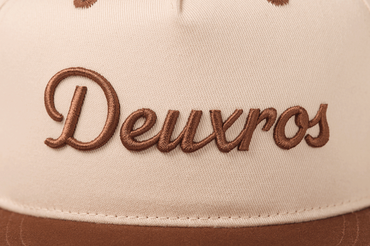 deuXros snapback close-up embroidery detail, tonal brown script on cream canvas
