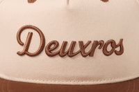 deuXros snapback close-up embroidery detail, tonal brown script on cream canvas