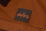 Close-up of a brown leather tag with a 'deuxros' brand label.