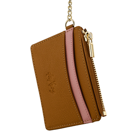 A brown leather card holder wallet with a pink textured stripe across the middle, a gold zipper, and a gold keychain attachment. The brand name 'deuXros' is embossed on the front.